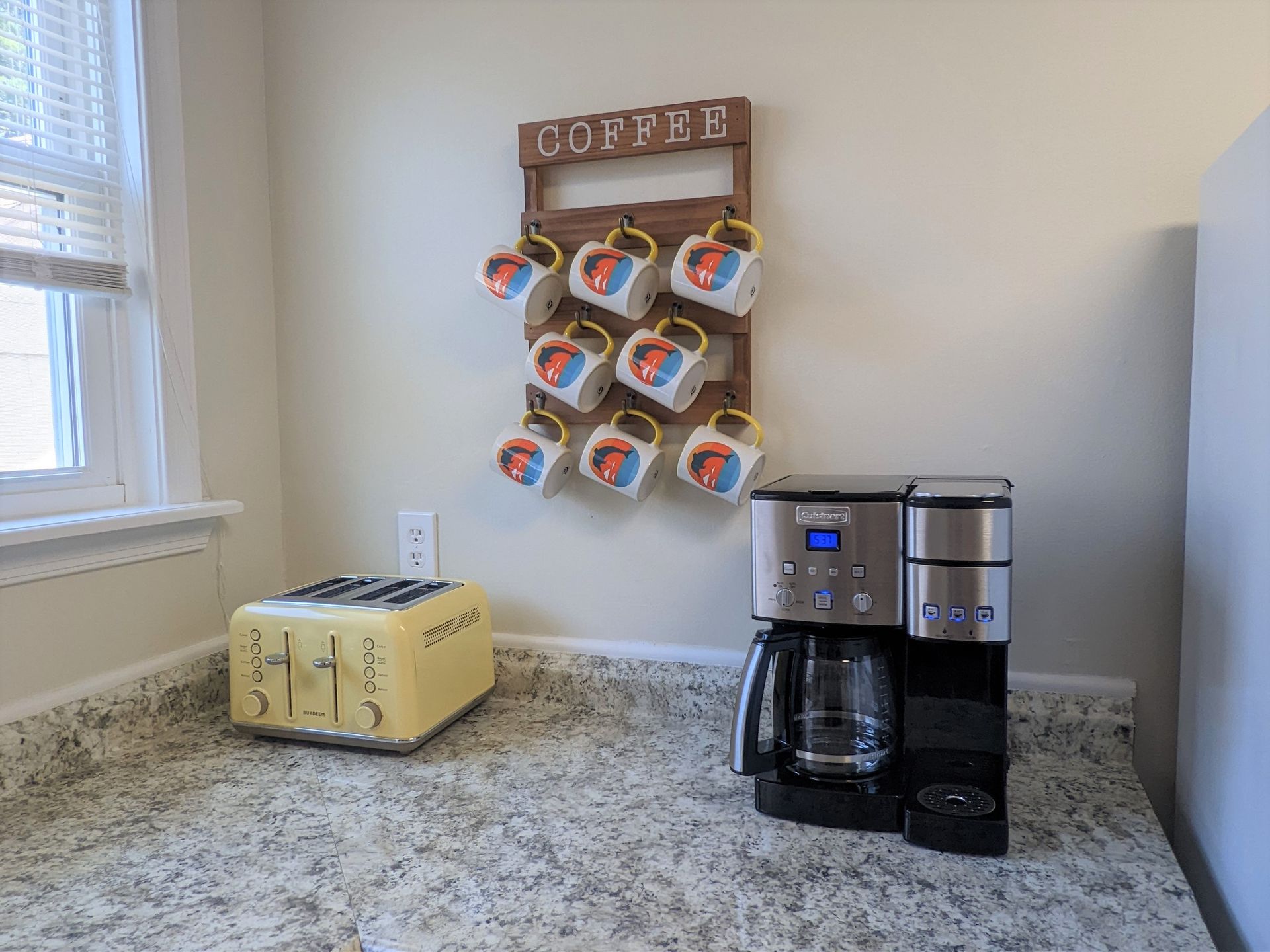 A coffee maker and a toaster are on a counter in a kitchen.