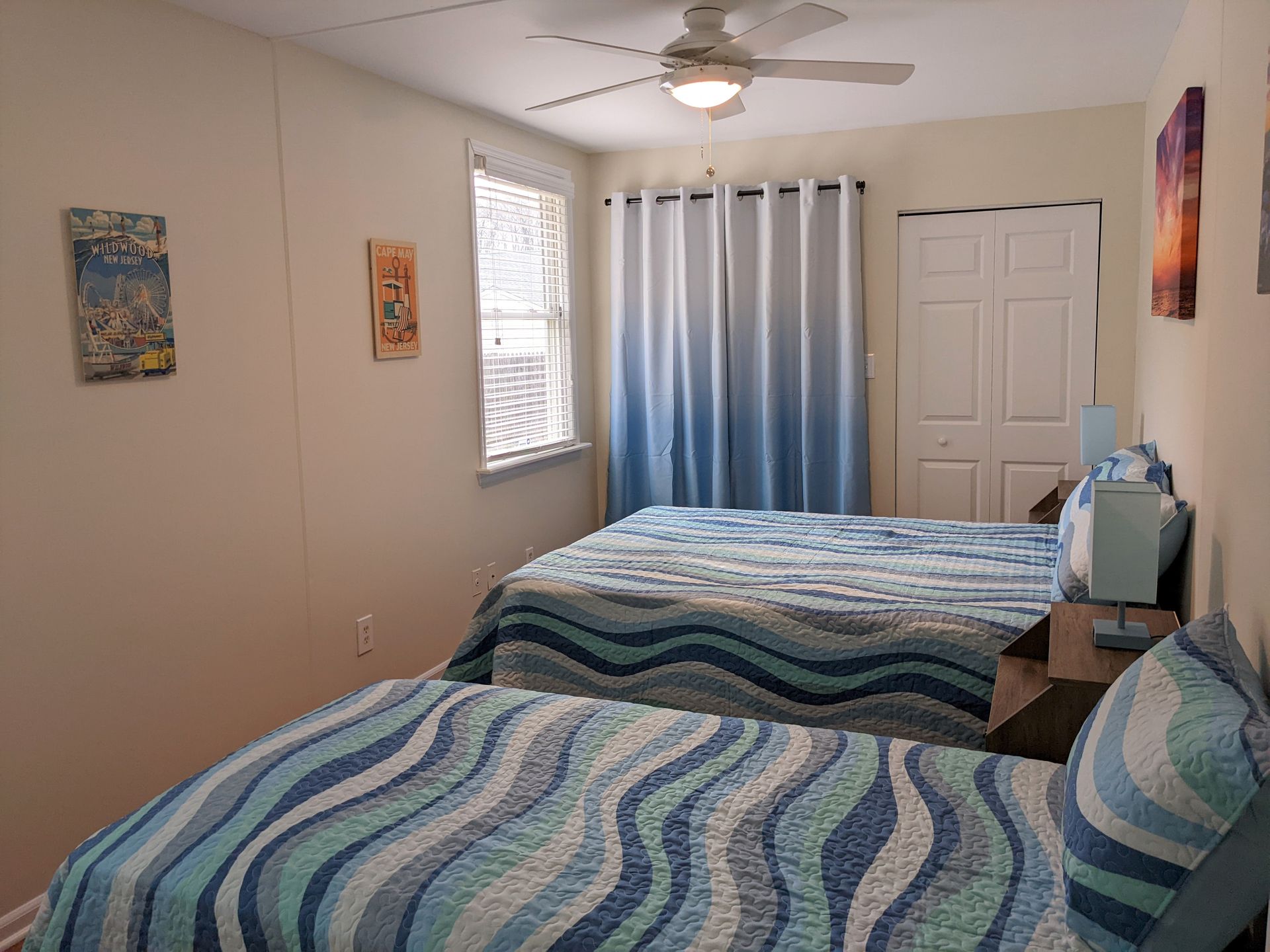 A bedroom with two beds and a ceiling fan.