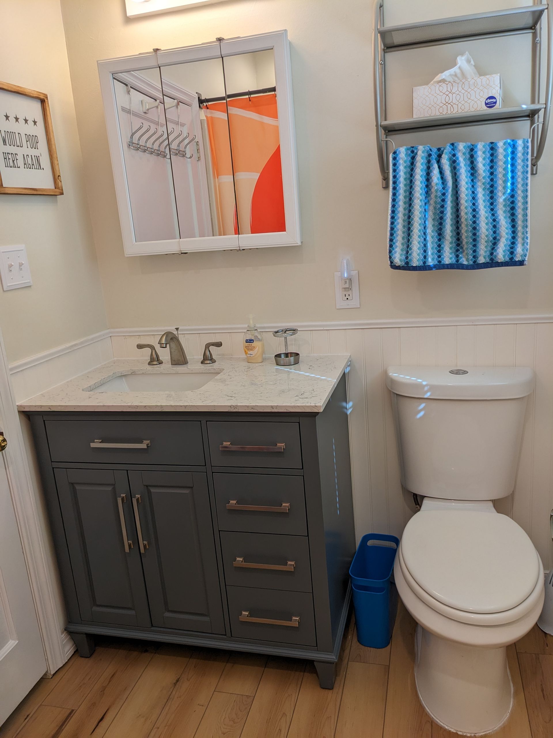 A bathroom with a toilet a sink and a mirror