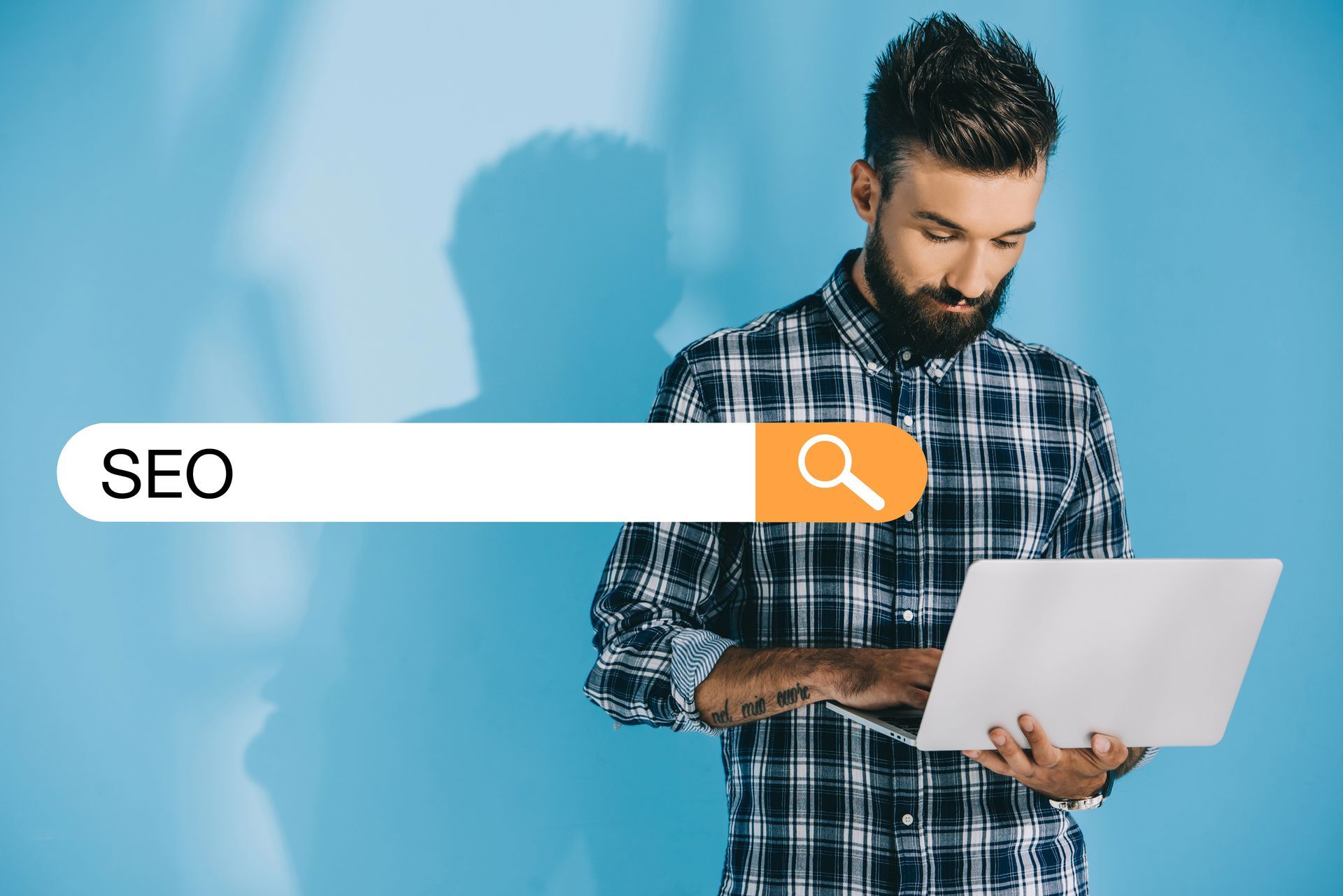 Man holding a laptop beside a search bar labeled “SEO” on a blue background