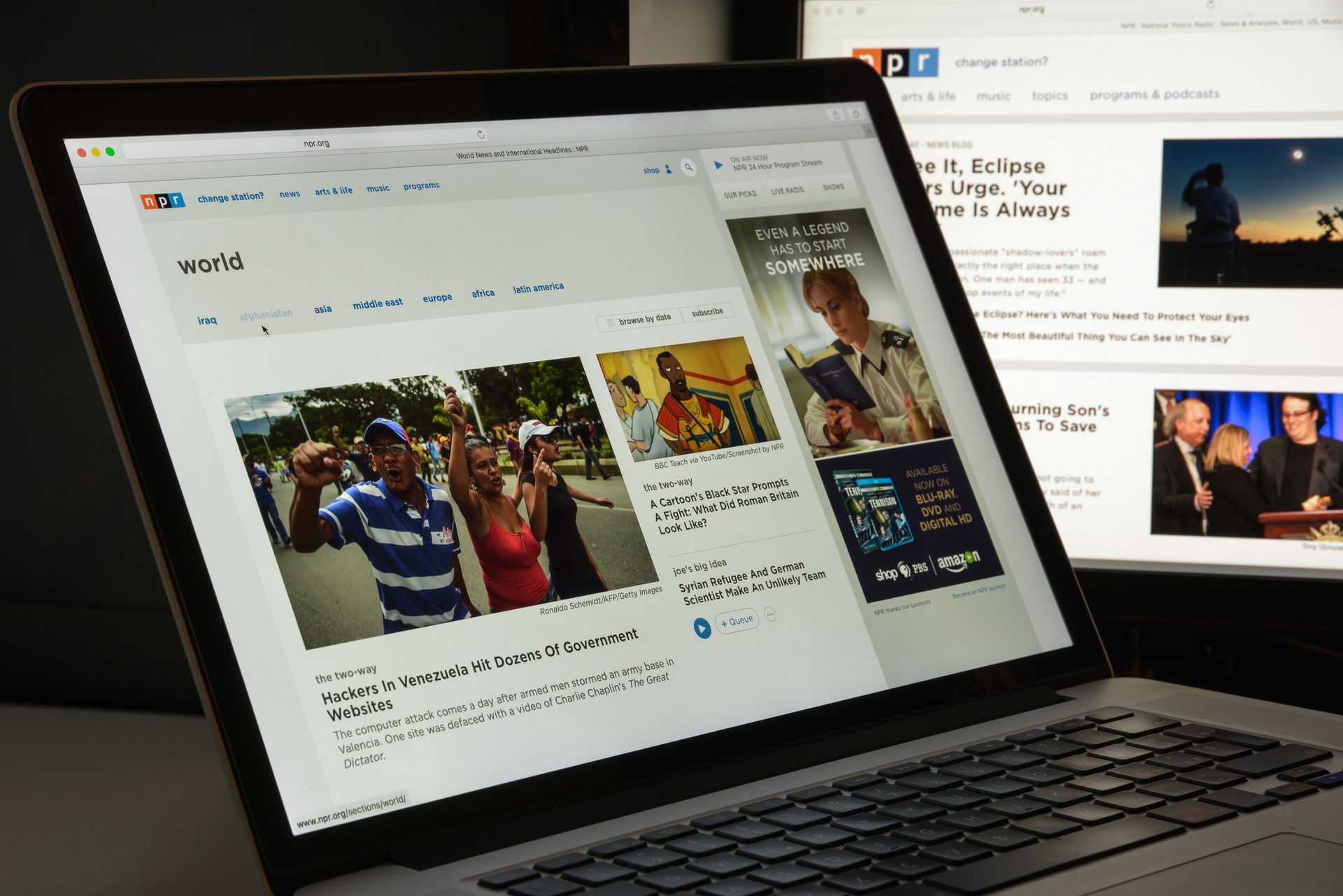 Laptop displaying a news website with photos, viewed at an angle on a desk