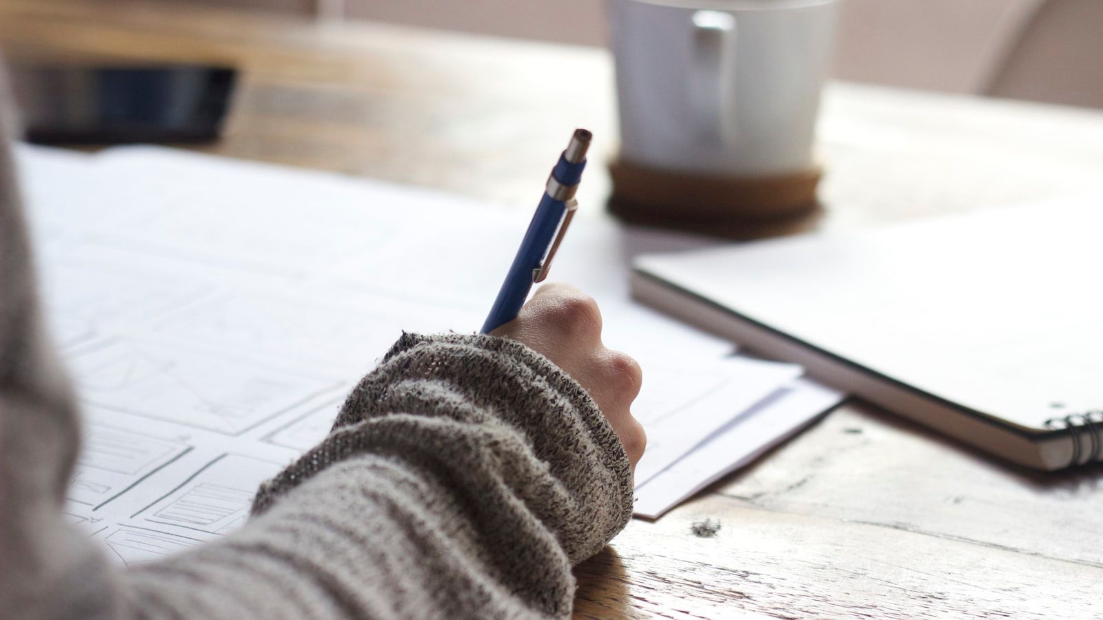 person writing on paper with pen