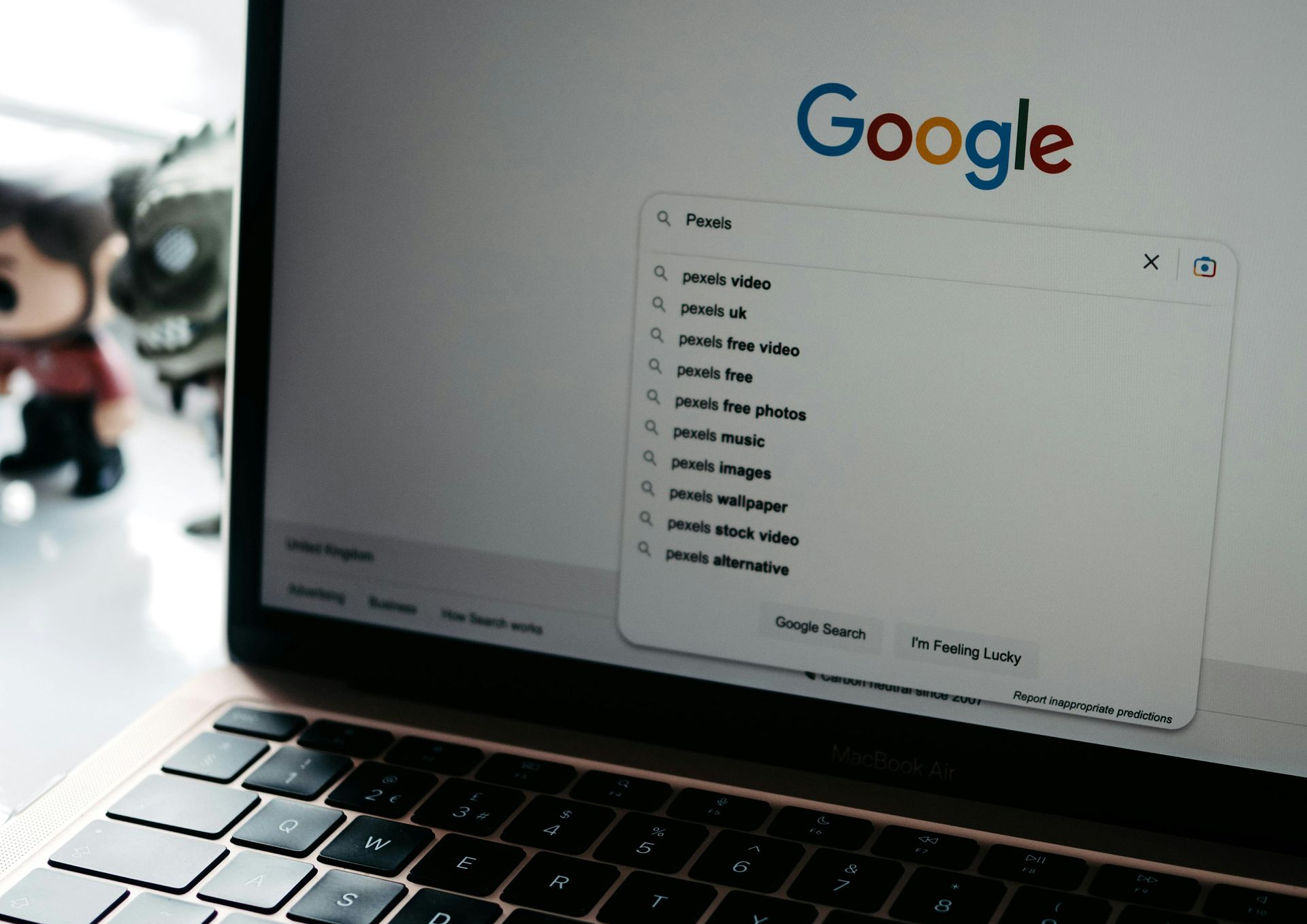 Laptop displaying Google search page with suggestions list open