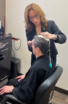Flora Fuentes, taking measurements of a customer's head at Unique Hair Concepts in New York