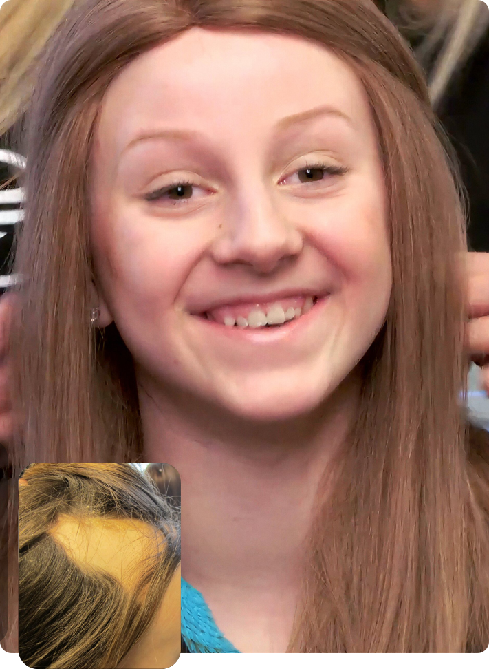 Close-up portrait of a smiling person with long light brown hair, wearing a blue top.