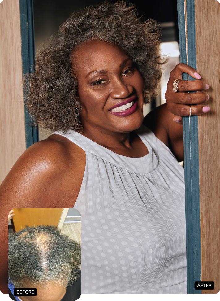 Smiling woman with curly hair in a sleeveless white top, leaning against a doorway.