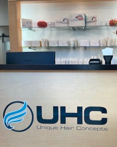 Unique Hair Concepts salon counter with shelves of products and decor behind it