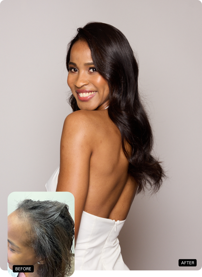 Woman in a white strapless dress smiling over her shoulder against a light gray backdrop.