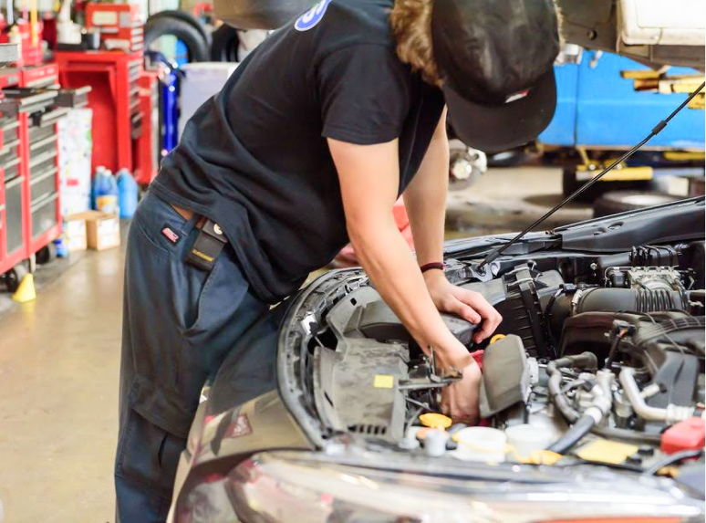 Expert technician at work under vehicle's hood in our garage in Monroe, WA | Monroe Goodyear
