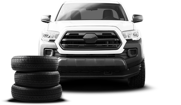 White truck with column of tires stacked | Monroe Goodyear