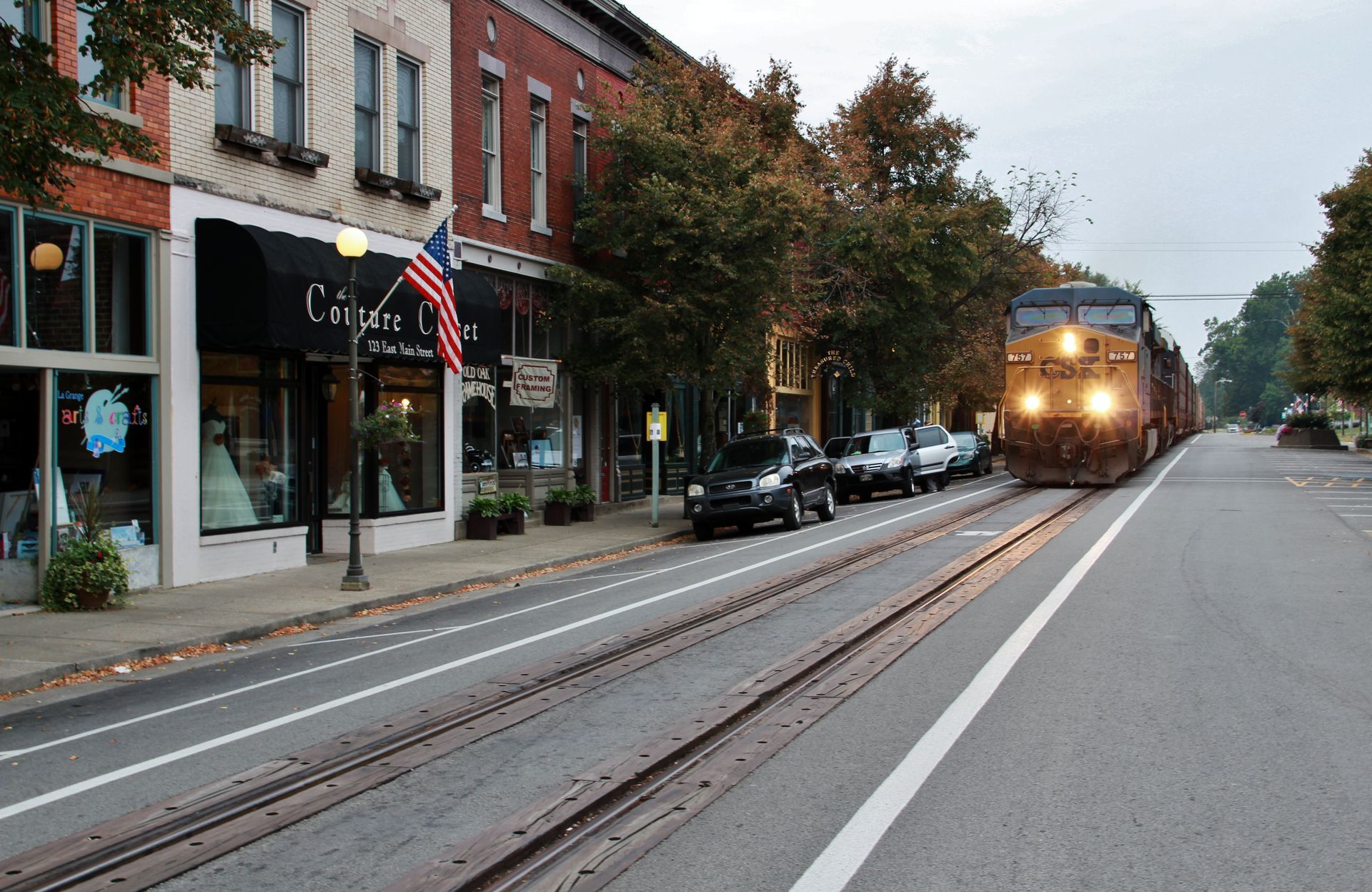 A train is going down the tracks in a small town