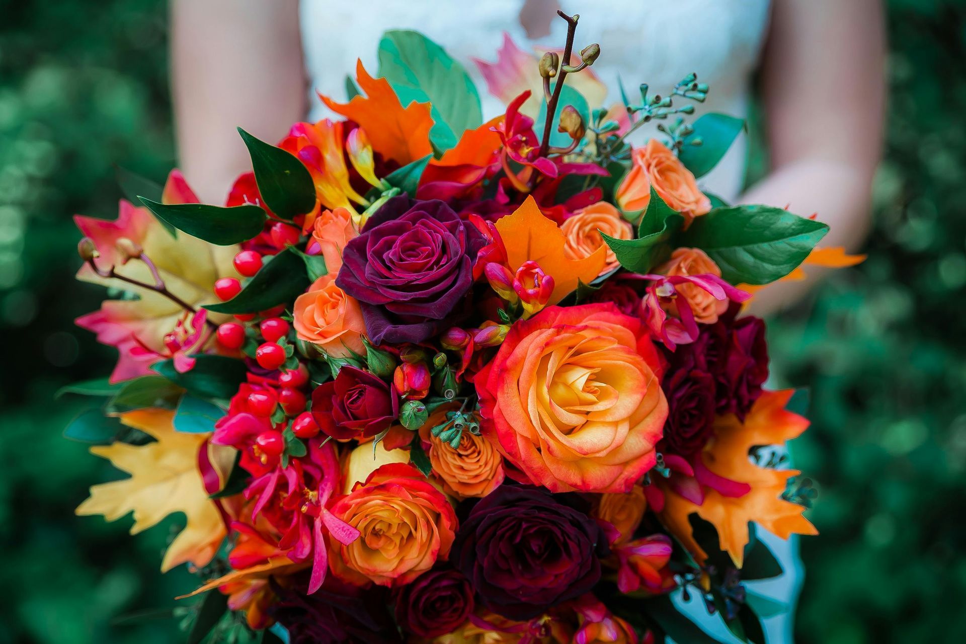 Potpourri sits in a hands-shaped bowl near a dried flower bouquet