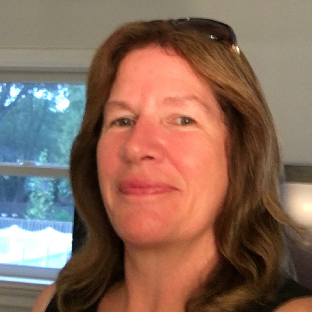 A close up of a woman 's face with sunglasses on her head