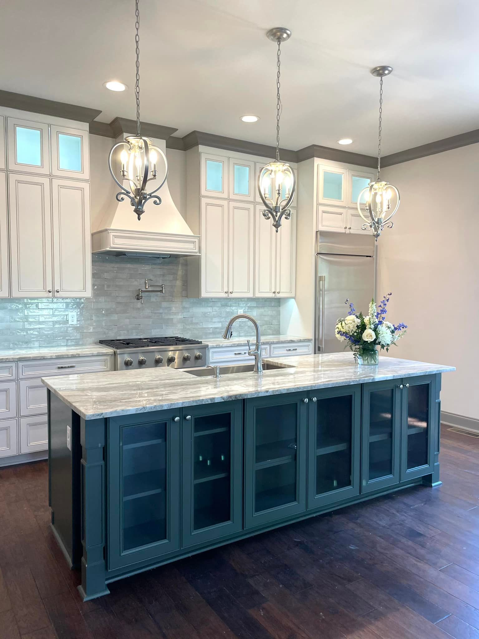 A kitchen with a large island and white cabinets