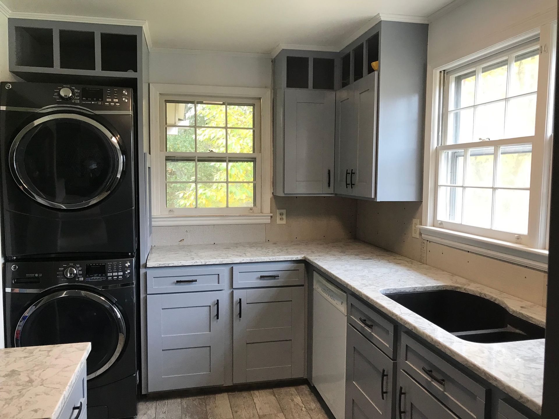 A kitchen with a washer and dryer stacked on top of each other.