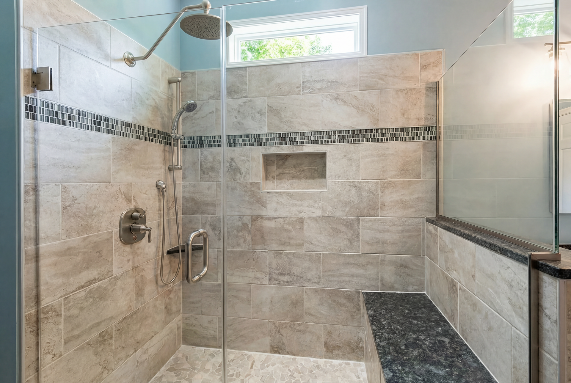 Modern tiled walk-in shower with glass enclosure, bench, and small window above.