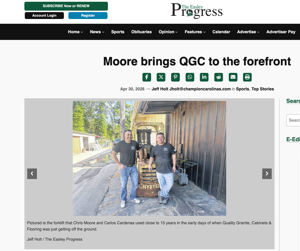 Two men standing on a gravel path under a hillside, shown in a news article page.