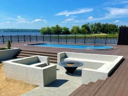 Custom concrete patio with fire pit by top Seattle WA concrete contractors, overlooking scenic view.
