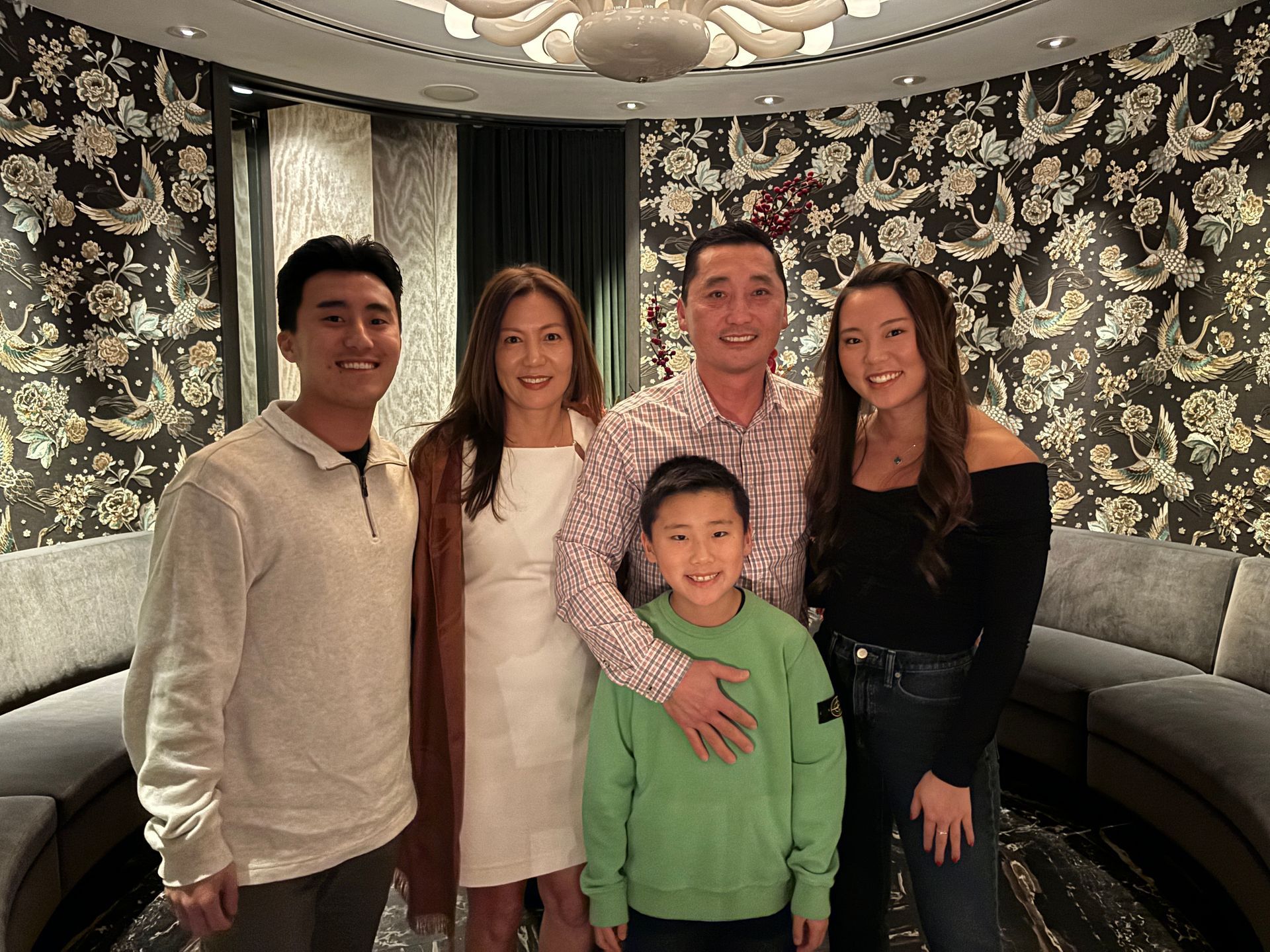 A family is posing for a picture in a living room.