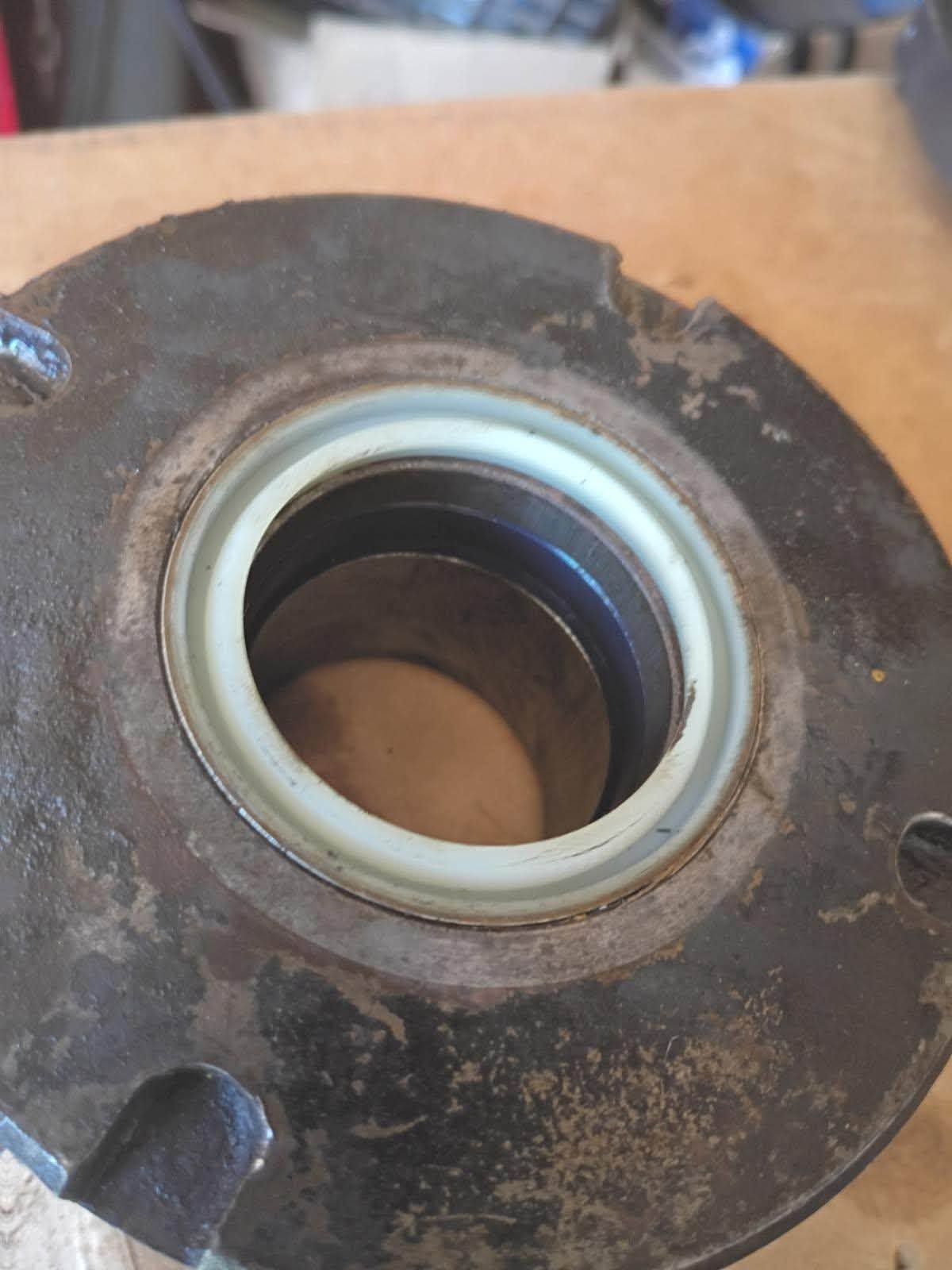 Close-up of a rusty metal flange with a central bearing or seal ring.