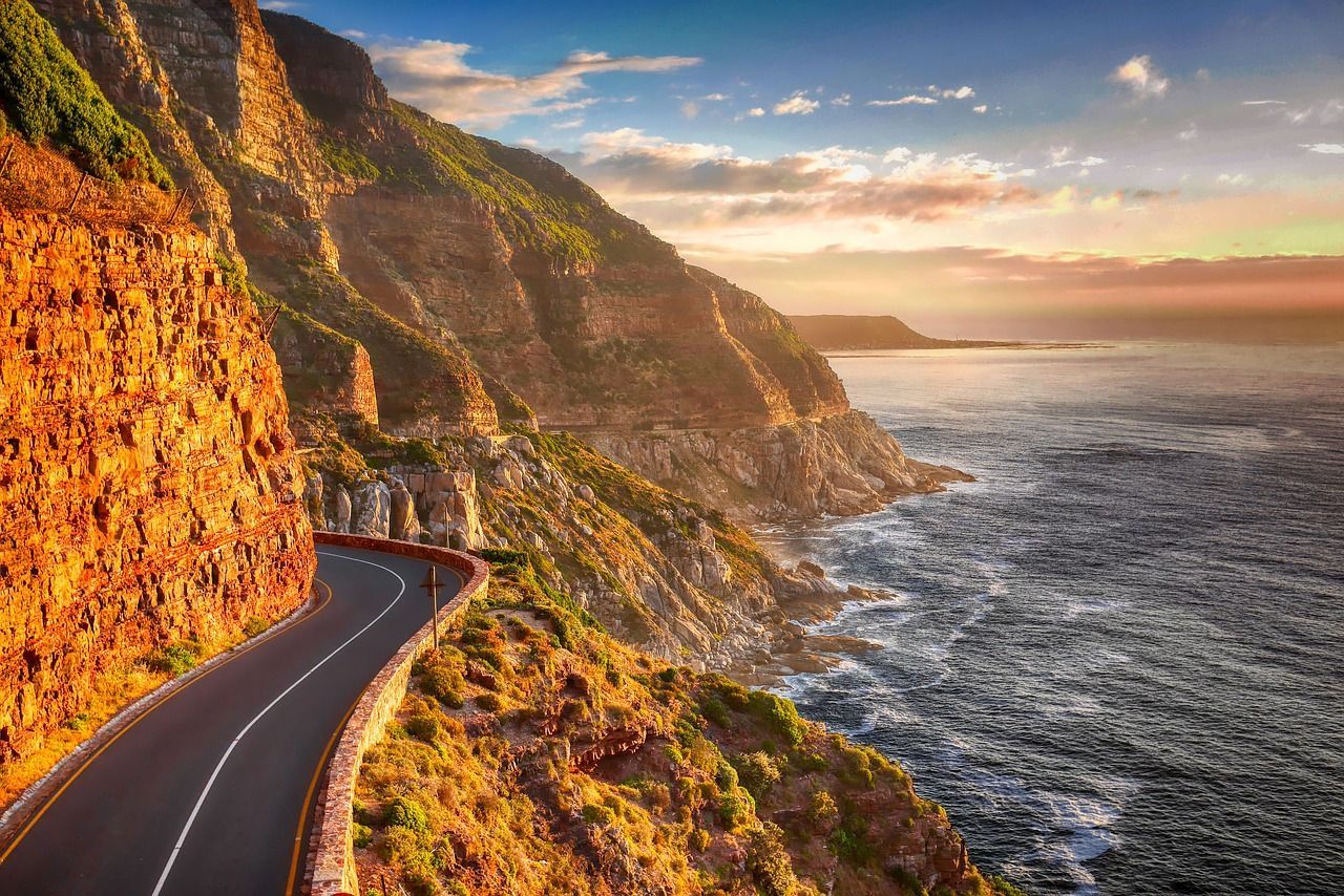 A road going down a cliff next to the ocean.