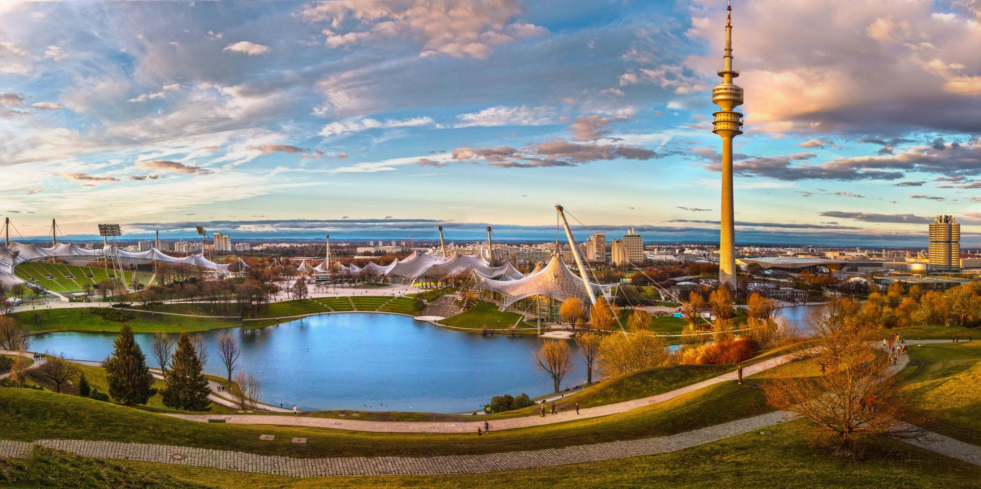 A panoramic view of a Bavarian city with a lake and a tower.