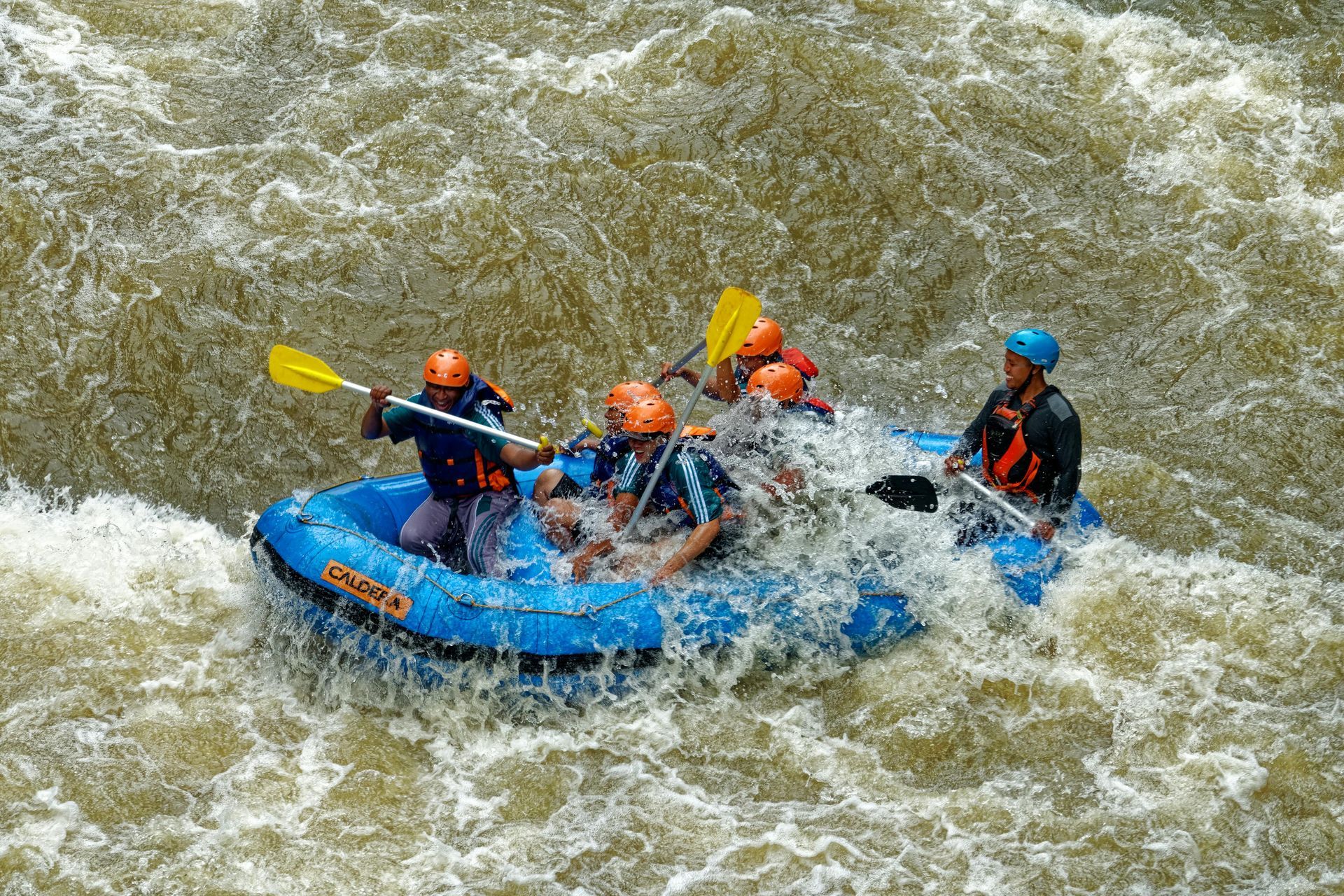 A group of people are white water rafting down a river.