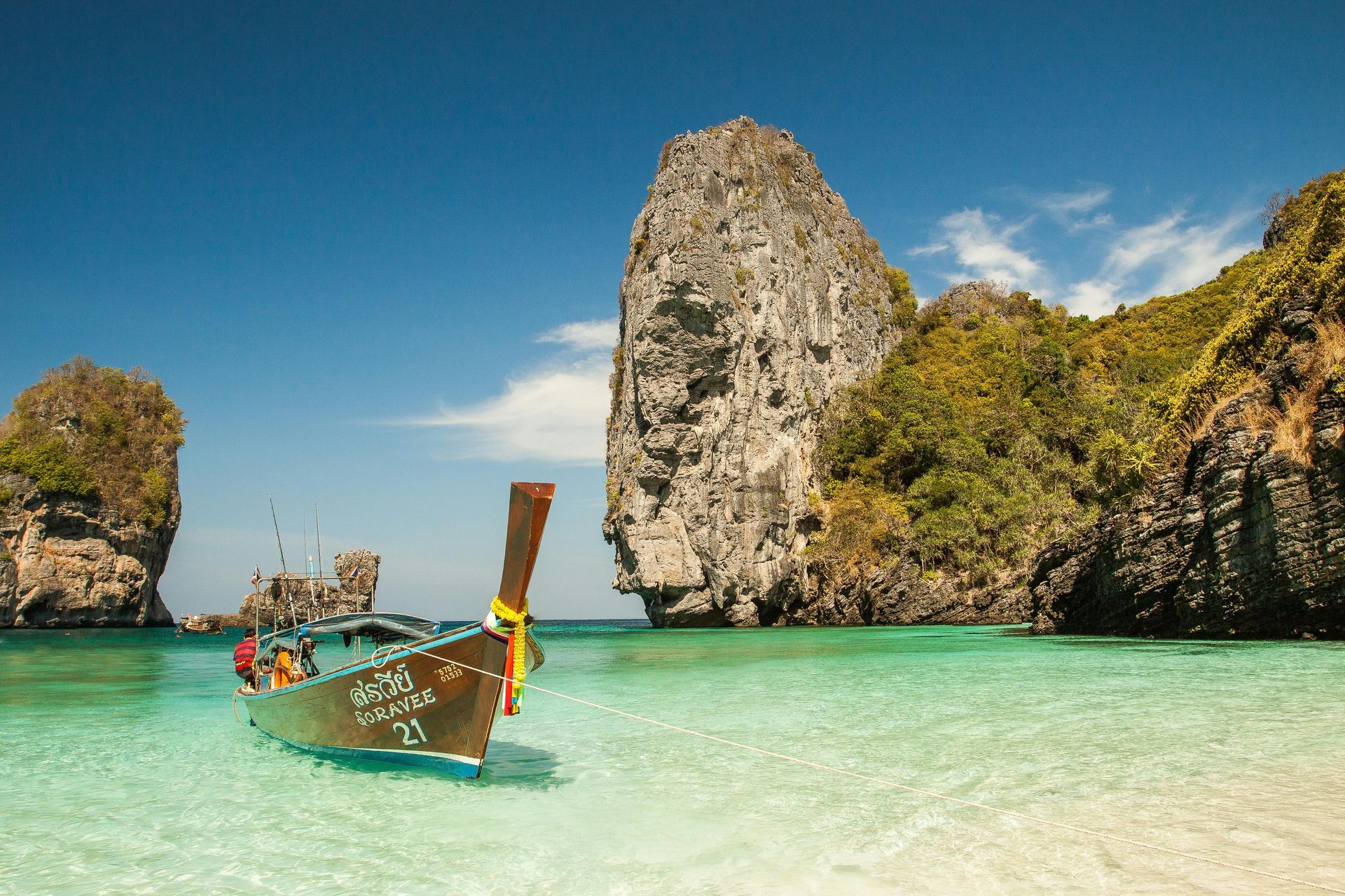 A boat is sitting in the water on a beach in Southern Thailand