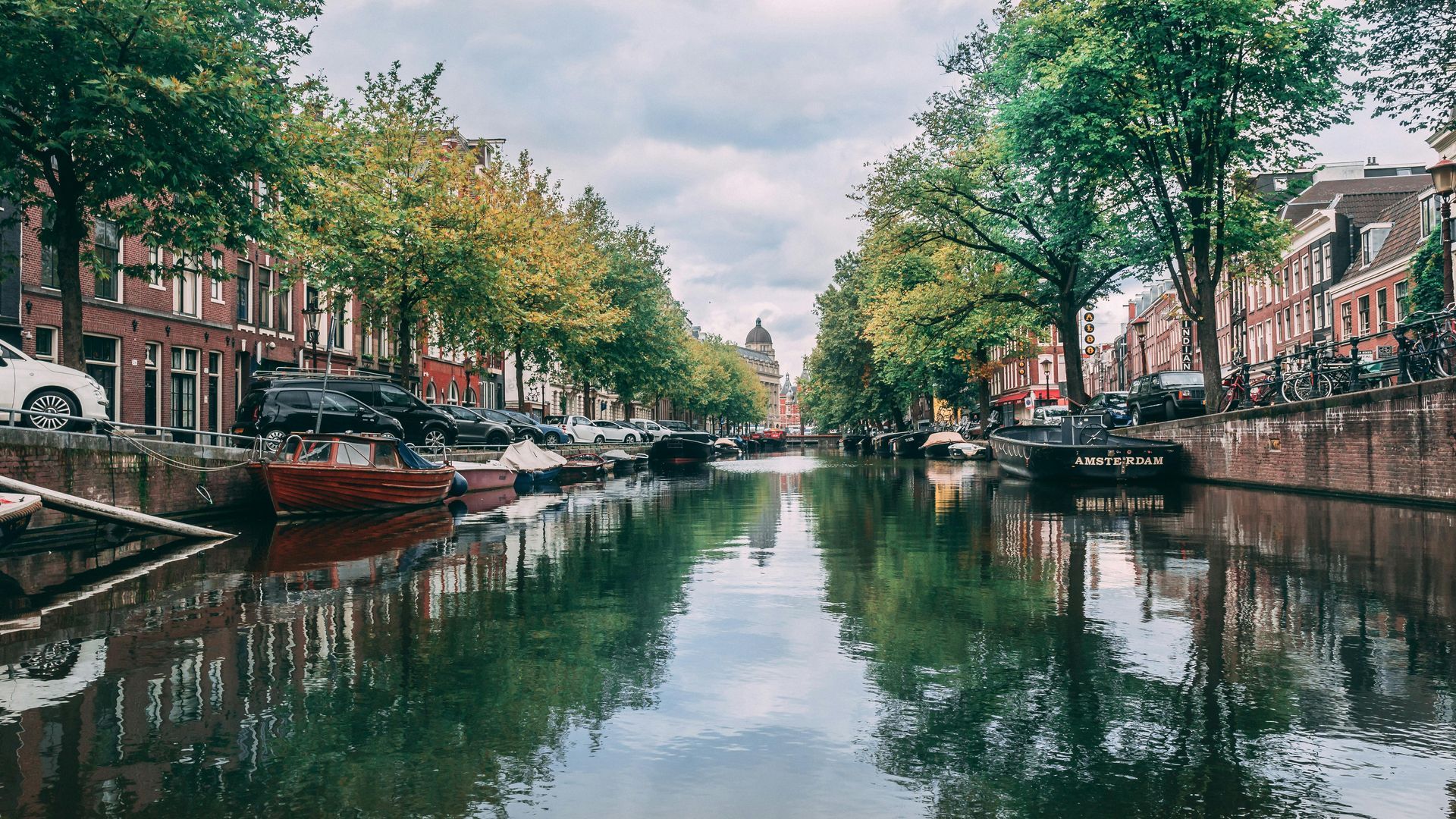 A canal surrounded by trees and buildings in the city of Amsterdam.
