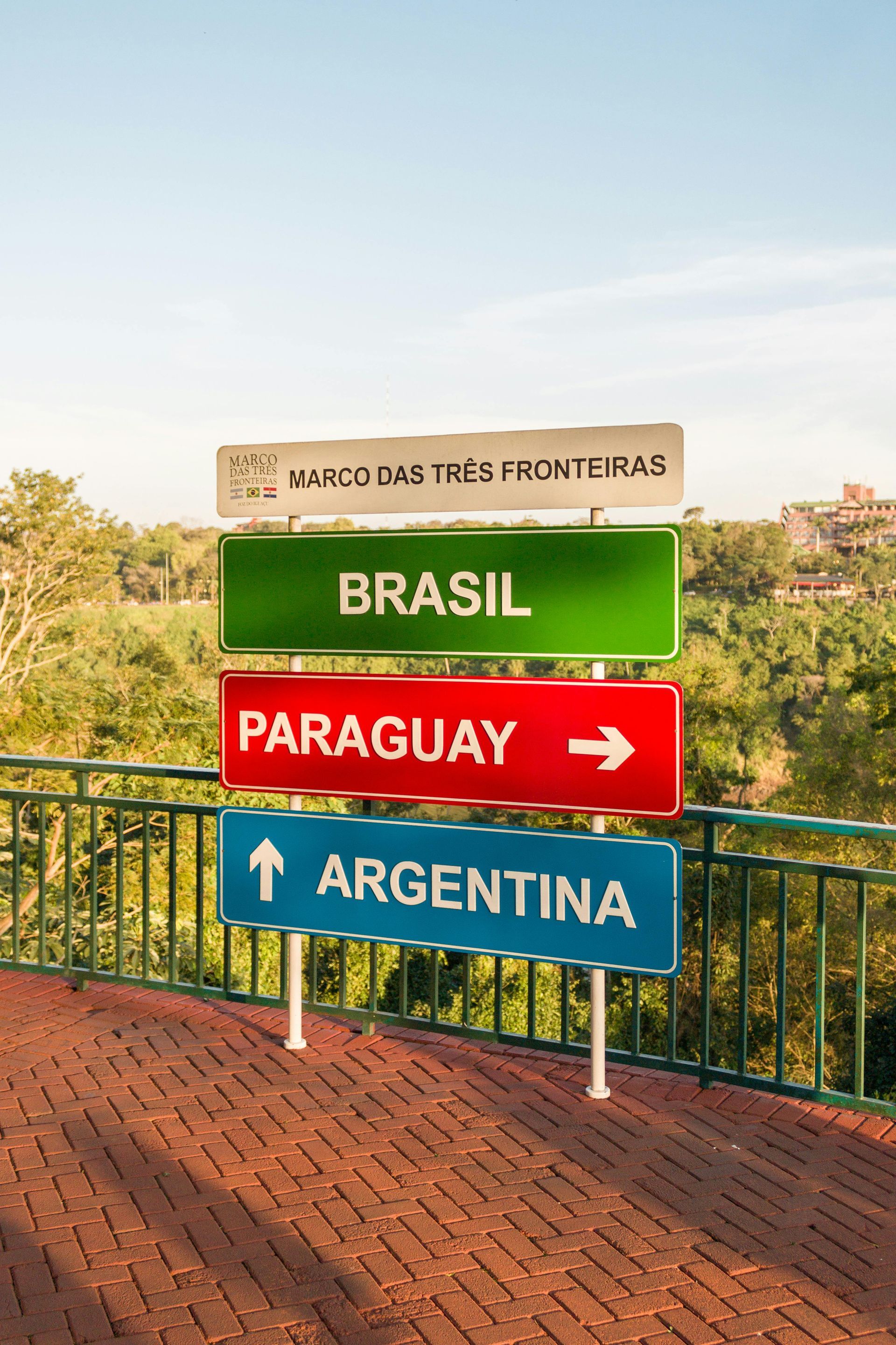 Signpost at Marco das Três Fronteiras (Three Borders Landmark) points to Brazil (green), Paraguay (red), Argentina (blue).