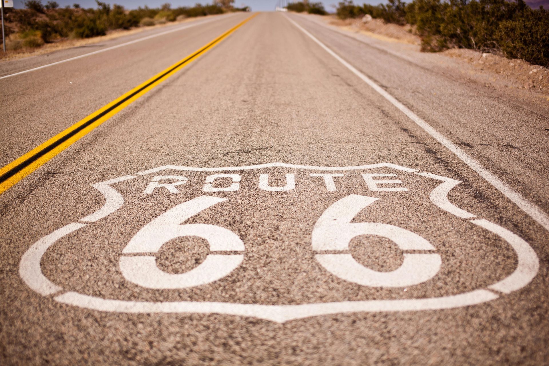 A route 66 sign is painted on the side of a road