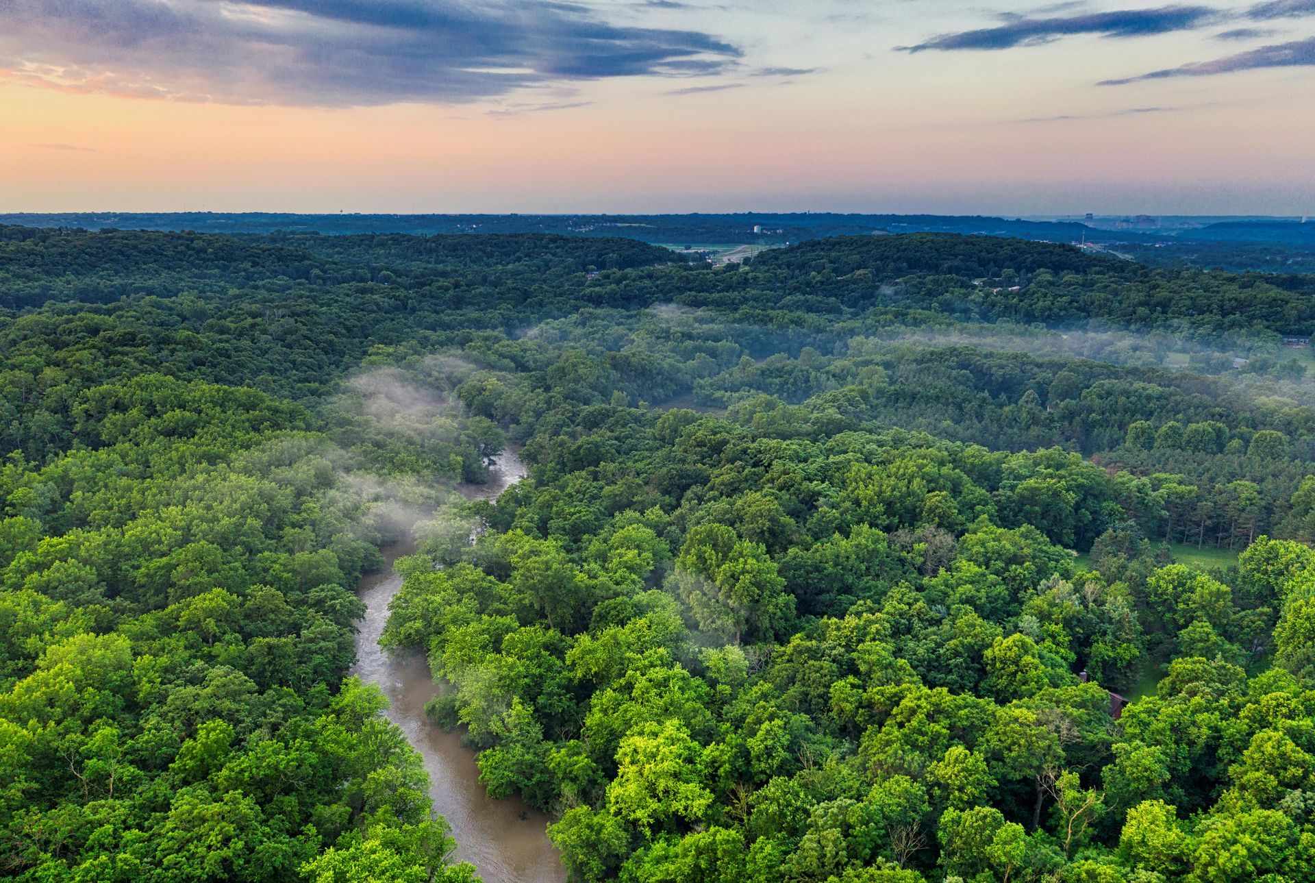An aerial view of a river running through a lush green Amazon.