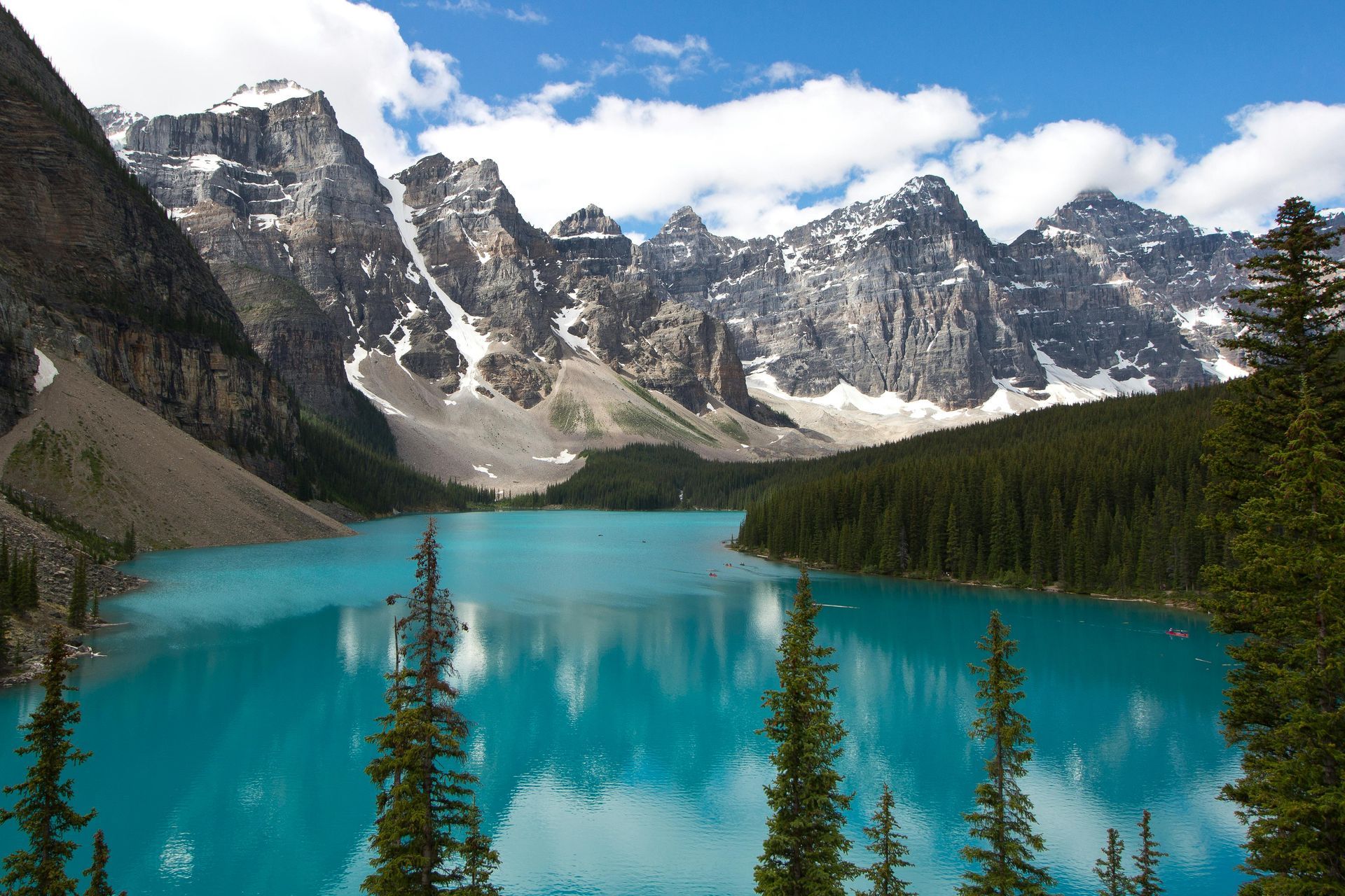 Turquoise-blue Moraine Lake in Banff National Park, Canada, framed by snow-capped mountains and evergreen forest.