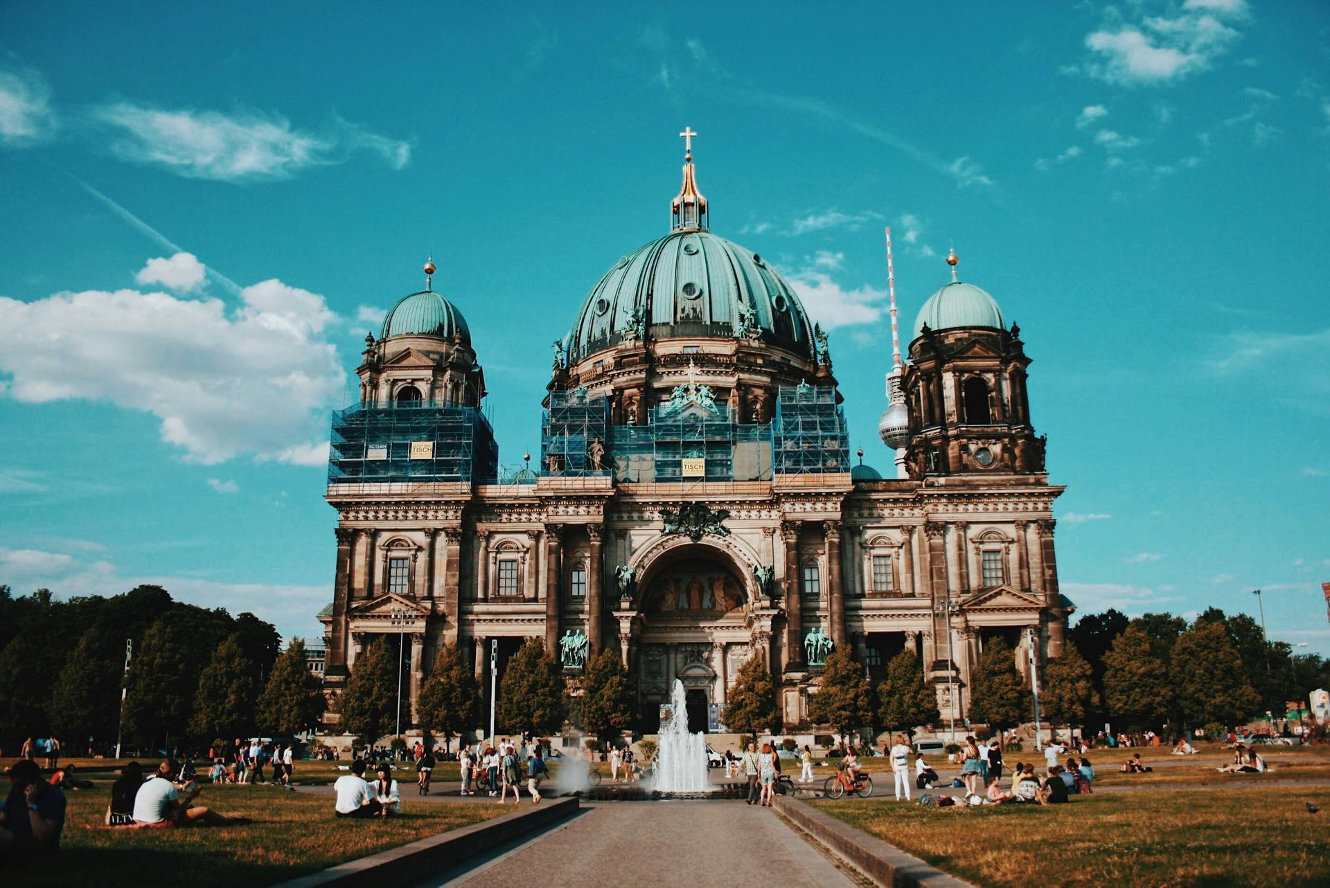 A large building with a dome in the middle of a park.