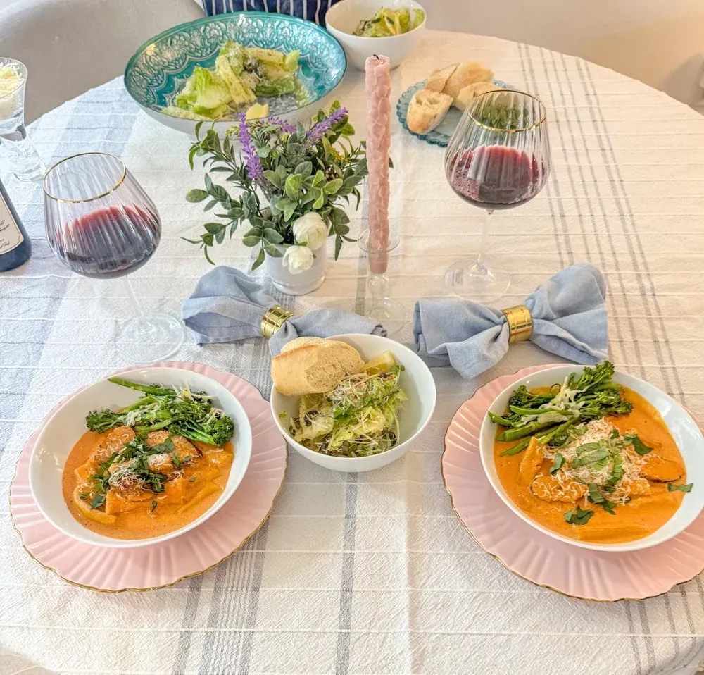 A top-down view of a salad, a shrimp pasta dish, and a menu branded 