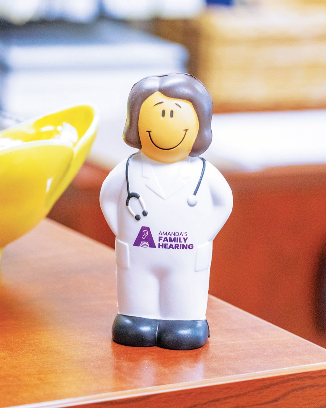 A small, cartoon-style figurine of a medical professional wearing a white lab coat with a stethoscope.