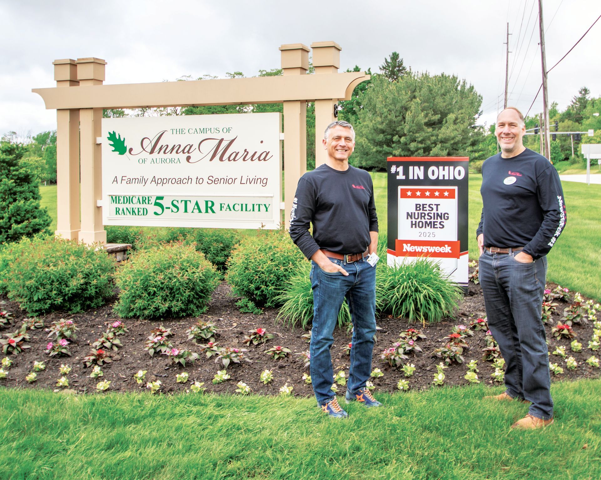 Two men stand smiling in front of an