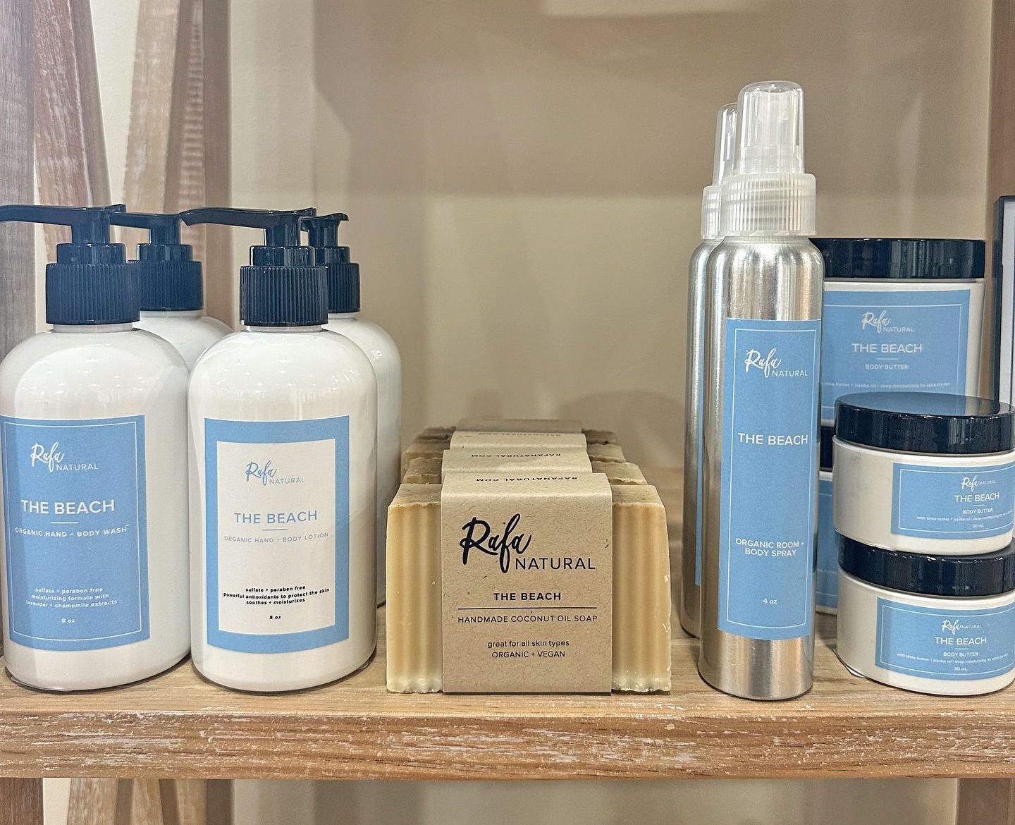 A shelf displaying Refa Natural skincare products, including lotions, a spray, balms, and bars of soap in blue packaging.
