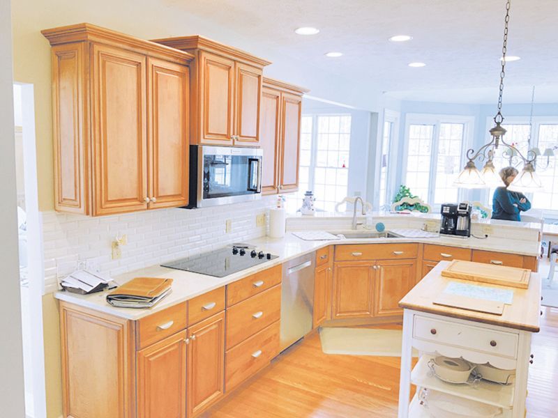 Kitchen with light wood cabinets, white countertops, a central island, and a stainless steel appliance suite.