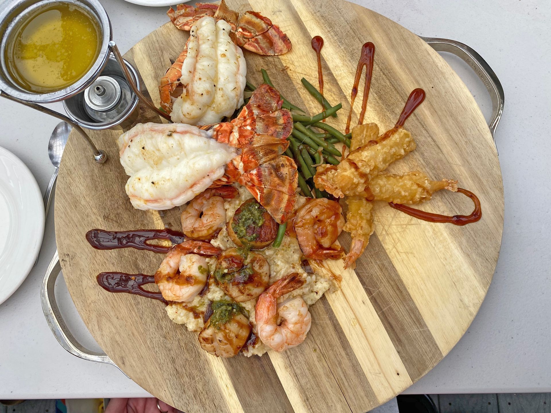 A top-down view of a salad, a shrimp pasta dish, and a menu branded