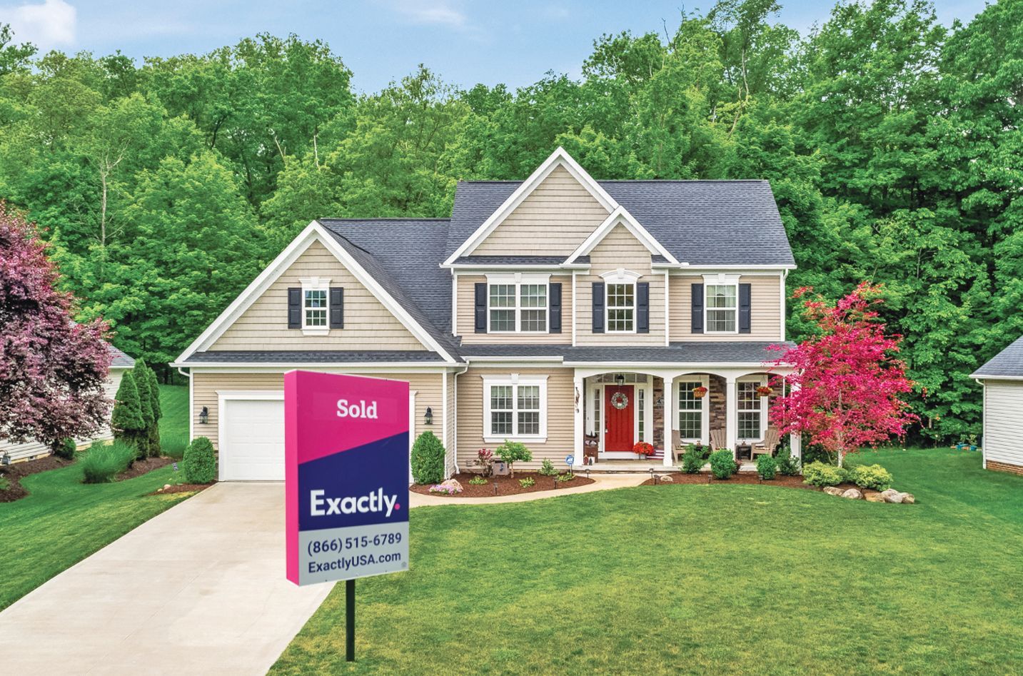 A beige two-story suburban house with a dark roof and a red front door, featuring a