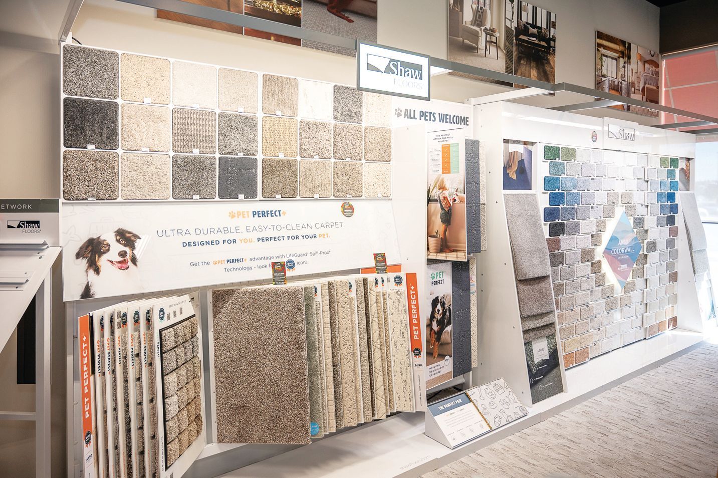 A showroom display showing various carpet and flooring tile samples arranged on shelves and panels.