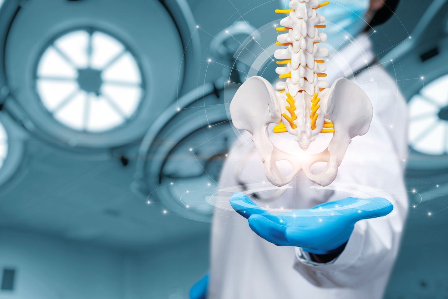 A surgeon in a sterile operating room holding a glowing, 3D holographic projection of a human spine and pelvis.
