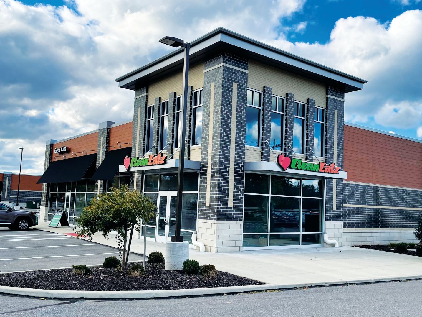 A modern retail building with brick and stone accents, large windows, and a 