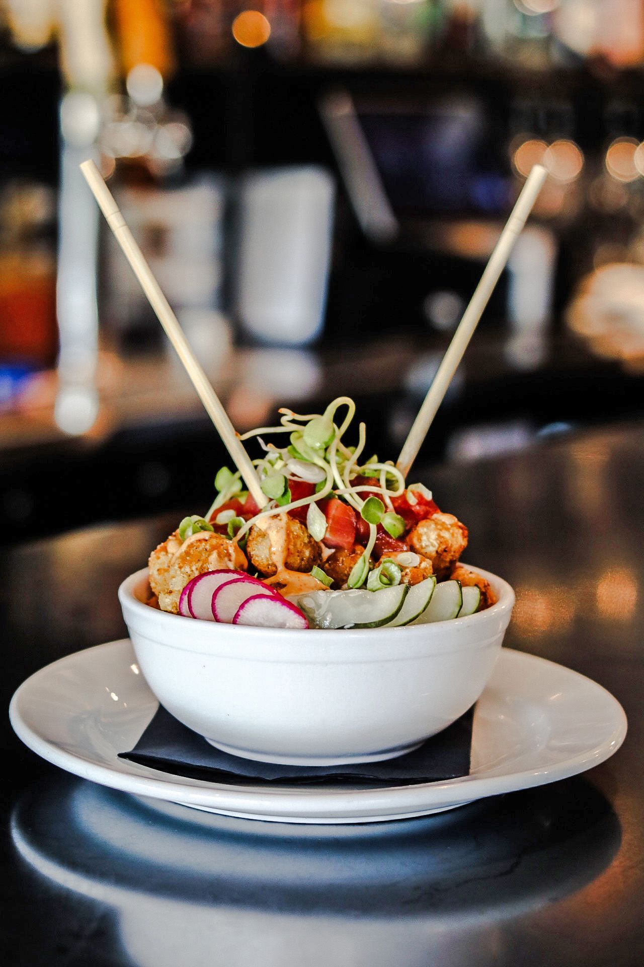 A top-down view of a salad, a shrimp pasta dish, and a menu branded