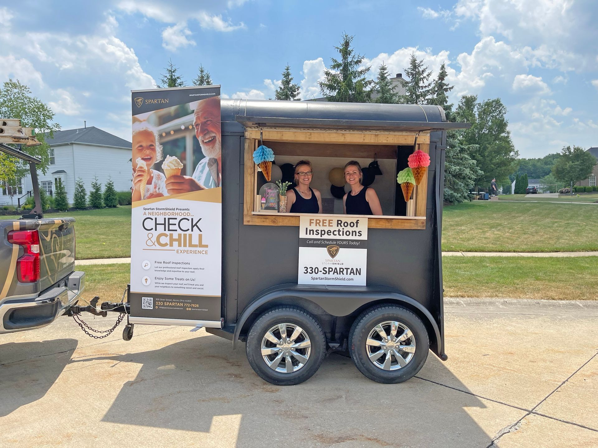 A mobile ice cream trailer hitched to a truck, featuring a 