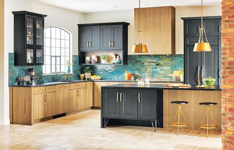A kitchen with black upper cabinets, wood lower cabinets, a teal backsplash, and a central island with two bar stools.