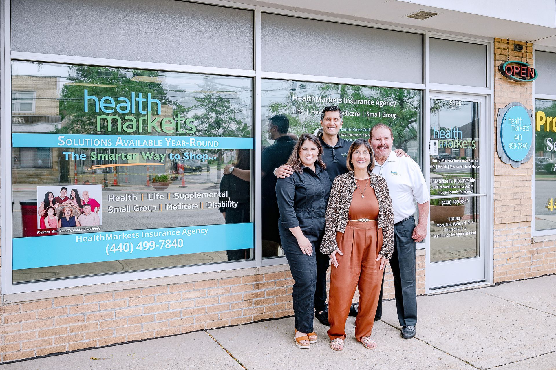 Four people stand smiling in front of a