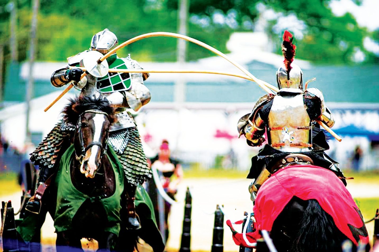 Two knights in full armor on horseback charge toward each other, holding long lances during a jousting match.