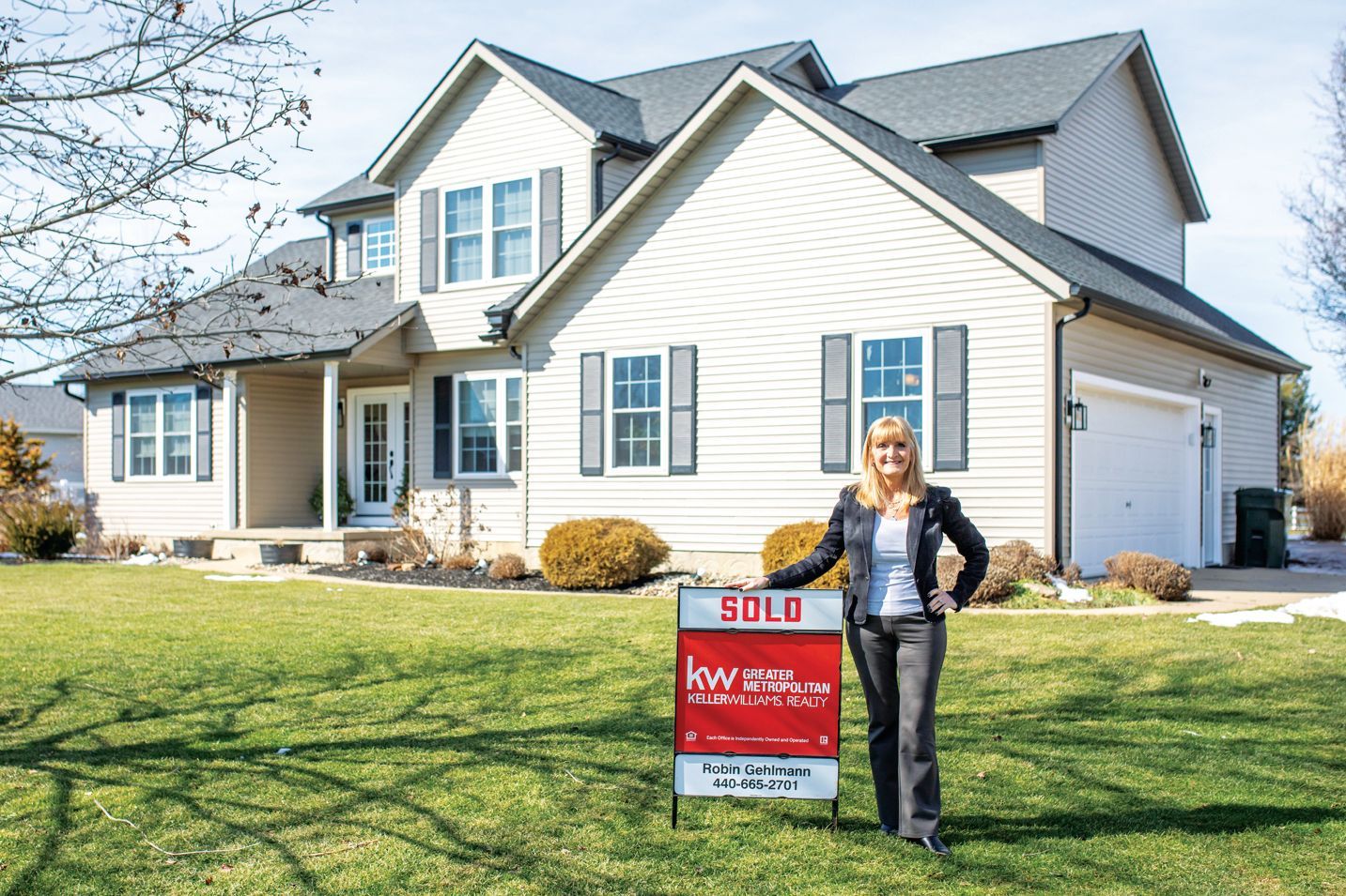 A woman stands on a lawn next to a